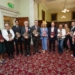Press shot of Minister Patrick O'Donovan and others holding copies of the report